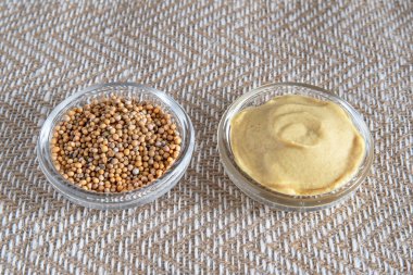 Hardal tohumları ve cam kaselerde sarı hardal yakın plan.