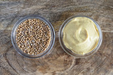 Hardal tohumları ve cam kaselerde sarı hardal yakın plan.