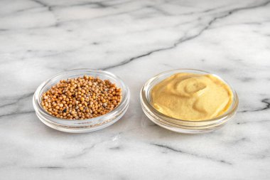 Hardal tohumları ve cam kaselerde sarı hardal yakın plan.