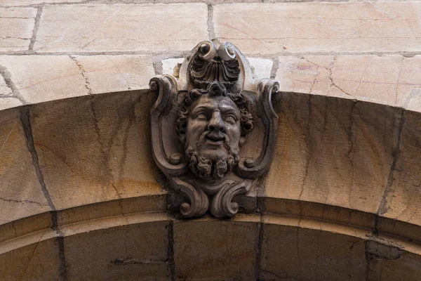 Fransa 'nın Burgundy kentindeki Dijon şehrindeki bir evin kapısına bir yüz oymanın ayrıntıları