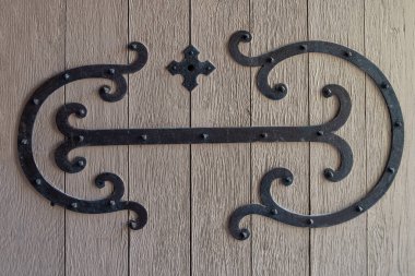 Arabesk şeklinde işlenmiş demir süslemeli eski bir ahşap kapının ayrıntıları.