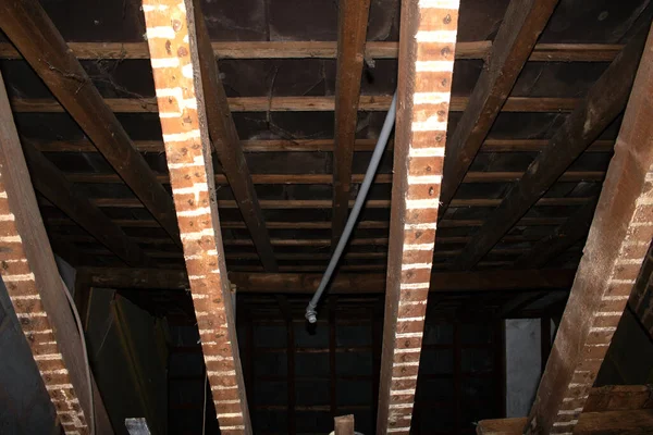 Çatı ve kirişleri gösteren soyulmuş tavan kirişleri ve çatıyı gösteriyor.