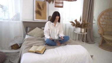 4k young woman with tablet pc computer in bed at home bedroom