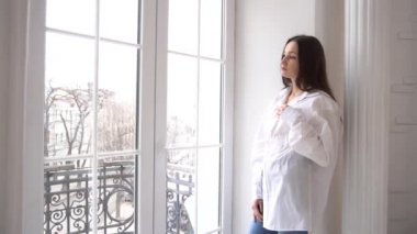 Slow Motion woman looking out window at home