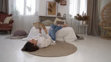 Yatak odasında kitap okuyan güzel bir kadın.