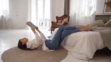 Dairenin içinde rahat bir çatı katı tasarımı, elinde kitap tutan bir kadın. 