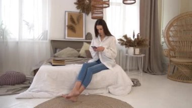 Female spending time online, texting with friends in cozy bedroom 