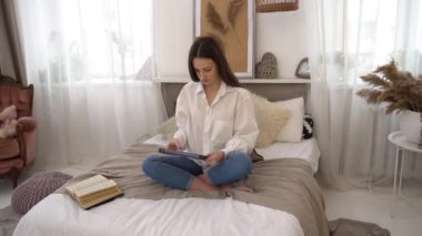 Mutlu kız evde yatakta yatıyordu bir Tablet video izleme