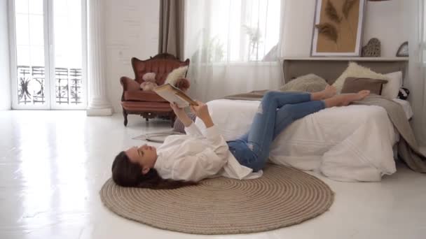 Young White Woman Reading Book Lying Floor Bedroom Blanket — Stock Video