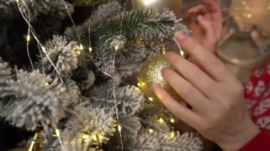 Slow Motion Woman decorating Christmas tree at home, closeup
