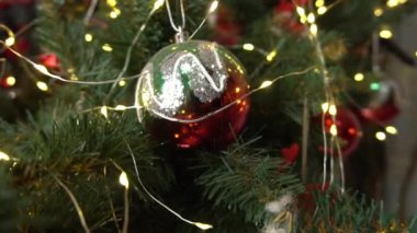 Slow Motion. Kırmızı elbiseli güzel kız Noel ağacının yanında yerde oturuyor.