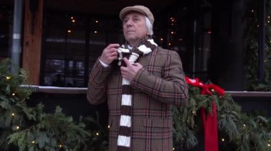Slow Motion Senior man in a winter overcoat standing in city