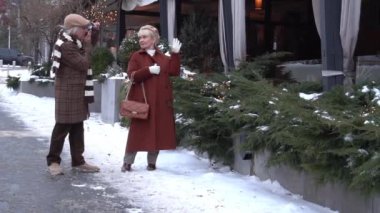 Slow Motion Güzel yaşlı çift şehir merkezinde yürüyüş yapıyor ve fotoğraf çekiyorlar.