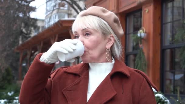 Happy Mature Woman Smiling Camera While Drinking Hot Chocolate — Stock video