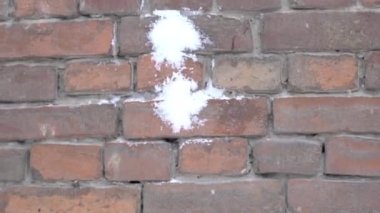 Üzerinde dört kartopu olan tuğla duvar. Yakın plan.