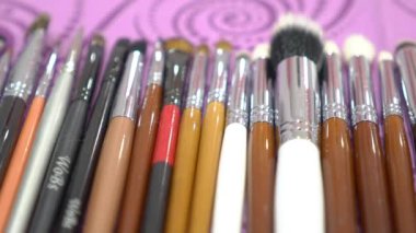 Slow Motion Set of brushes make up application tools laying on a table 