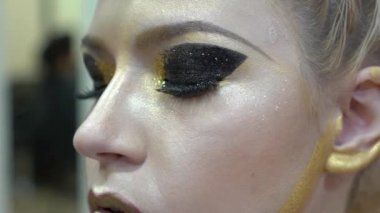 Makeup process, makeup artist using brush and compact powder and colors model 