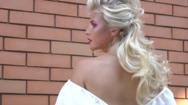 Slow Motion Beautiful blonde hair girl back fashion hairstyle on brick wall