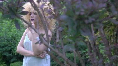 Beautiful woman is smiling. The blonde with curly hair laughs. Afro hairstyle.