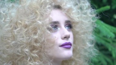 Slow Motion Portrait of a young beautiful woman rounded by plants
