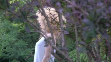 Slow Motion Beautiful blond smiling woman with afro curly hair in the field