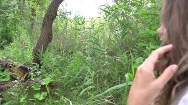 Slow Motion attractive woman walks outdoor in a white dress.