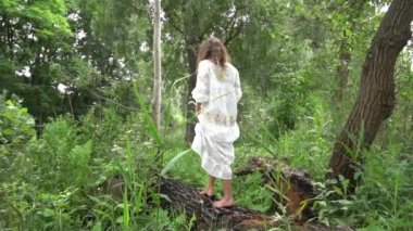 Slow Motion Young pretty attractive girl posing in nature, white dress