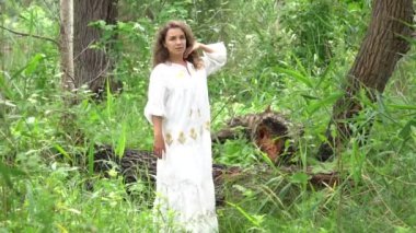 Slow Motion Beautiful young woman in white dress relaxing in tree garden