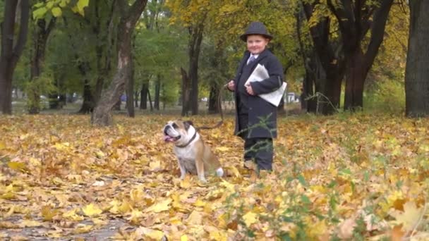 Chłopiec Garniturze Biznesowym Gazetą Jesiennym Parku Buldogiem — Wideo stockowe