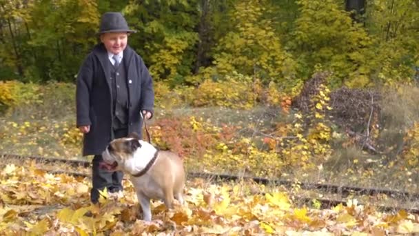 Lindo Niño Traje Negro Con Bulldog Mascota Parque Otoño — Vídeo de stock