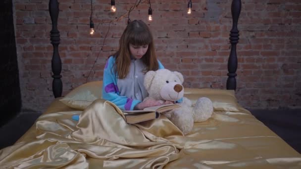 Κορίτσι Παιδί Στο Κρεβάτι Διαβάσει Βιβλίο Αρκουδάκι Βελούδινο Παιχνίδι — Αρχείο Βίντεο