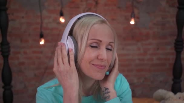 Γυναίκα Ακουστικά Ακούγοντας Μουσική Κάθεται Ένα Κρεβάτι Στην Κρεβατοκάμαρα — Αρχείο Βίντεο