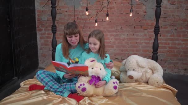 Αδελφές Κορίτσια Θέσει Κρεβάτι Διαβάστε Βιβλίο Μαζί Παιδιά Ετοιμάζονται Κοιμηθούν — Αρχείο Βίντεο