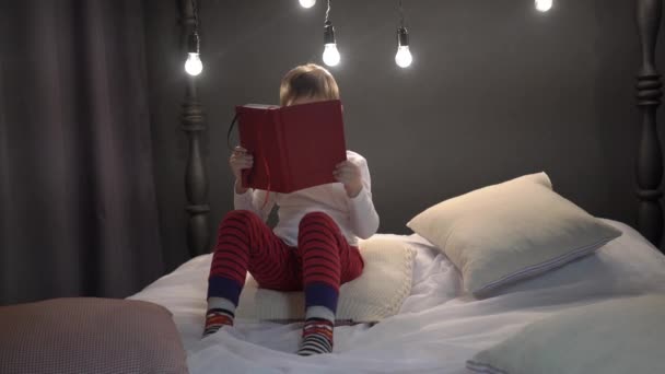 Adorable Boy Reading Fun Children Book His Bedroom — Stockvideo