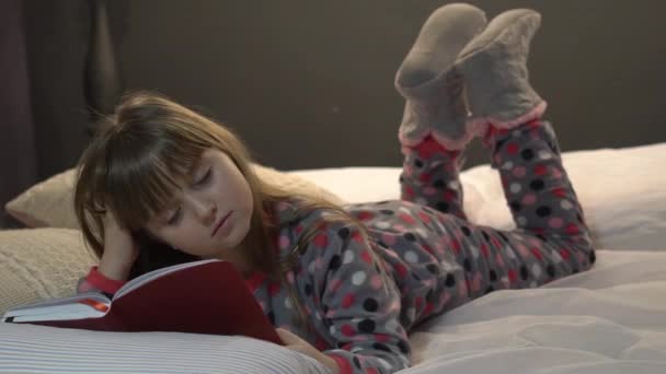 Niña Leyendo Libro Viendo Fotos Cama Antes Irse Dormir — Vídeo de stock