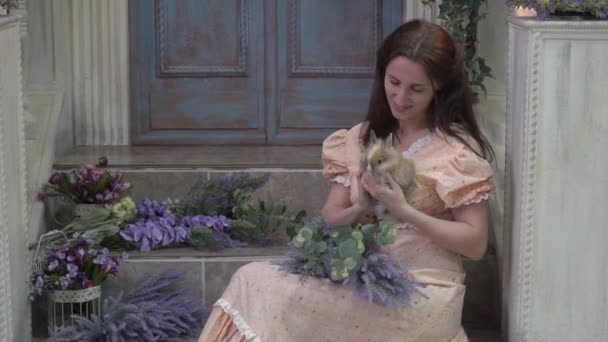 Young Woman Simple Dress Small Rabbit Hands Sitting Lavender — ストック動画
