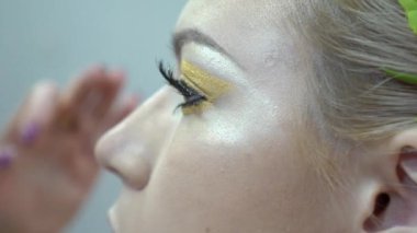 Woman applying by professional make up master. 