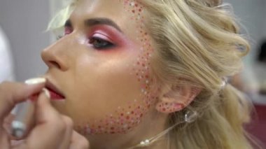 4k makeup artist applying lipstick on model lips with brush