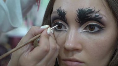 Slow Motion Makeup artist creating beautiful makeup for brunette model