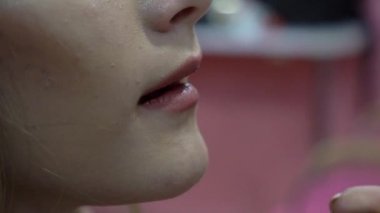 Slow Motion Female makeup artist applies rose lipstick. Beautiful females