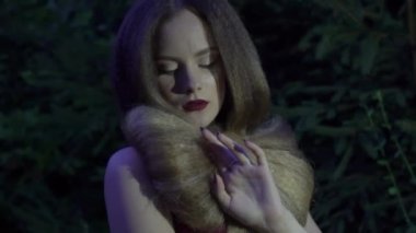 A portrait of a young fashionable smiling woman in the park