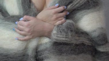 Young caucasian female model covered herself with white sheet and poses