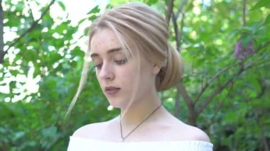 Beautiful bride in wedding dress at green park background