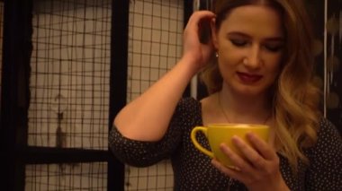 Restoranda tek başına kahve içen genç bir kadının 4K yakın çekimi.