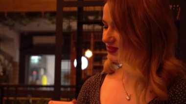 4K Genç kadın kafede, kafede akıllı telefon kullanıyor. 