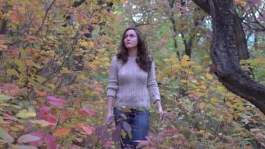 Beautiful woman walks through the autumn forest 