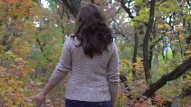Slow Motion Beautiful young woman posing in the autumn park.