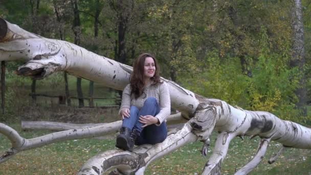 Красива Жінка Сидить Дереві Парку Осіннім Листям — стокове відео