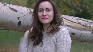 Slow Motion Güzel esmer Sonbahar parkında bir ağaçta oturuyor