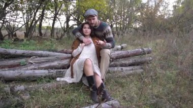 Slow Motion genç çifti ormanda yürürken kütüğün üzerinde dinleniyor.